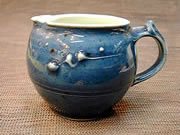 blue glazed pitcher with trailing slip decoration 